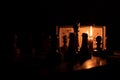 Chess pieces stand on a chessboard and clock and next to a burning candle in the dark, playing Royalty Free Stock Photo