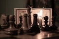 Chess pieces stand on a chessboard and clock and next to a burning candle in the dark, playing Royalty Free Stock Photo