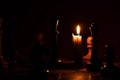 Chess pieces stand on a chessboard and next to a burning candle in the dark, playing Royalty Free Stock Photo