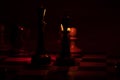 Chess pieces stand on a chessboard and next to a burning candle in the dark, playing Royalty Free Stock Photo