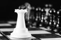 Chess pieces, a white rook on a chessboard, against a row of black pieces. The concept of career, competition, startup.