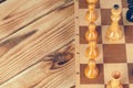 Chess pieces on a wooden chessboard against a dark background