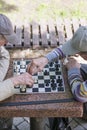 Chess player in the park. Old man plays chess in the park. vertical photo