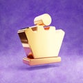 Chess queen icon. Gold glossy Chess queen symbol isolated on violet velvet background.
