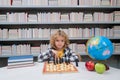 Chess school for children. Kid thinking about chess. The concept of learning and growing children. Chess, success and Royalty Free Stock Photo