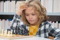 Chess school. Little kid play chess. Thinking child. Chess game for kids. Intelligent, smart and clever school boy. Royalty Free Stock Photo