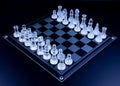 Chess set with glass pieces resting on dark surface Royalty Free Stock Photo