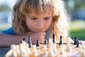 Chess strategy. Close up face of clever smart child. Kid playing chess.