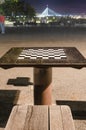 Chess table in the park in the night, big bridge in a distance