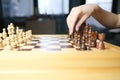 Chess tournament on a wooden board, a child and an adult play together, rearrange the pieces, the concept of sports tactics game,