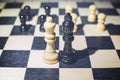 chessboard with Black king and white queen in front in the concept of agreement and pawns in the background Royalty Free Stock Photo