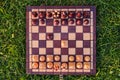 Chessboard and chess pieces on the grass in the garden Royalty Free Stock Photo