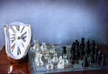 Chessboard game and Dali-like clock Royalty Free Stock Photo