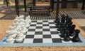 Chessboard with huge black and white chess figures for outdoor playing. Nice backgrounds Royalty Free Stock Photo