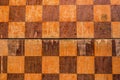 Old shabby chessboard texture top view. Chekered wooden background