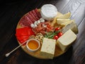 Chesse platte with different cheeses, meats on wooden board