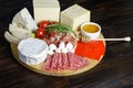 Chesse platte with different cheeses, meats on wooden board