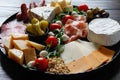 Chesse platter with cheese, prosciutto, tomato, nuts. Healthy eating, dairy, chesses and meat. Antipasti appetizer. Camembert, moz