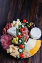 Chesse platter with cheese, prosciutto, tomato, nuts. Healthy eating, dairy, chesses and meat. Antipasti appetizer. Camembert, moz
