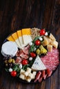 Chesse platter with cheese, prosciutto, tomato, nuts. Healthy eating, dairy, chesses and meat. Antipasti appetizer. Camembert, moz
