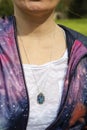 Chest detail in space jacket with labradorite pendant on silver chain Royalty Free Stock Photo