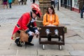 CHESTER, UK - 26TH JUNE 2019: The town crier locks up a tourist in a stockade in the middle of the city, summer 2019