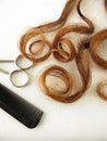 Chestnut-brown hair, scissors and comb Royalty Free Stock Photo