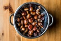 Chestnuts in metal pasta strainer to drain the water. Royalty Free Stock Photo