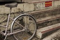 Modern bicycle parked beside a set of stairs on a sidewalk with a warning sign: \