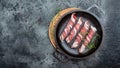 Chevapchichi with rosemary in Cast iron pan. Kofta kebab. raw sausages of ground beef or pork with spices wrapped in bacon. Royalty Free Stock Photo