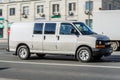 Chevrolet Express GMT610 driving on the street. Gray full-size van GMC Savana in motion on city road