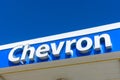 Chevron oil industry company sign on a roof of a Chevron gas station against blue sky