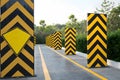 Warning Bollards and Yellow Line on Paved Surface with Greenery Background Royalty Free Stock Photo