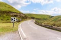 Chevron sign on a curve along a mountain road on sunny summer day Royalty Free Stock Photo