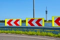 Chevron traffic road sign with red and white striped arrows warning of dangerous curve on street