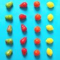 Chewing gum in the form of pear, orange, strawberry and lemon on a blue background Royalty Free Stock Photo