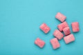 Chewing pink gum pieces on blue background. Space for text Royalty Free Stock Photo