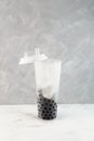 Chewy Tapioca balls Boba or Pearls in tall plastic take away cup. Preparating popular Taiwanese Boba drink or Bubble milk tea.