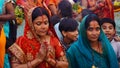 chhath pooja celebrate Indian women dressed in traditional clothes and standing in water