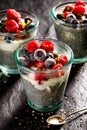 Chia pudding with addition of raspberries and blueberries in the glasses on a black background, healthy diet concept Royalty Free Stock Photo