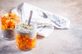 Chia pudding with persimmon and pumpkin seeds in glasses, gray background, copy space. Vegan food concept Royalty Free Stock Photo