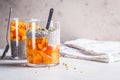 Chia pudding with persimmon and pumpkin seeds in glasses, gray background, copy space. Vegan food concept Royalty Free Stock Photo