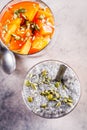Chia pudding with persimmon and pumpkin seeds in glasses, gray background, top view. Vegan food concept Royalty Free Stock Photo