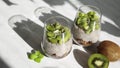 Chia seed pudding with coconut milk and kiwi in a glass with granola.
