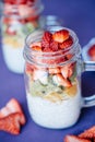 Chia seed pudding with Strawberry, kiwi, orange served in a Mason Jar on violet background Royalty Free Stock Photo