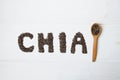 Chia seeds. Chia word made from chia seeds with spoon full of chia on white wooden background. Royalty Free Stock Photo