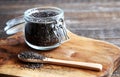 Chia seeds in a glass jar, a bowl on a wooden stand on a wooden table. Nearby lies a spoon with scattered seeds. Save the space. Royalty Free Stock Photo