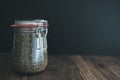 Chia seeds in glass weck jar on wooden table against dark background