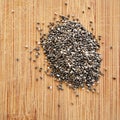 Chia Seeds on wood grain cutting board, square format for social media, banners and backgrounds.