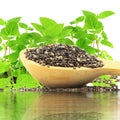 Chia seeds in wooden spoon with chia plant and water reflection Royalty Free Stock Photo